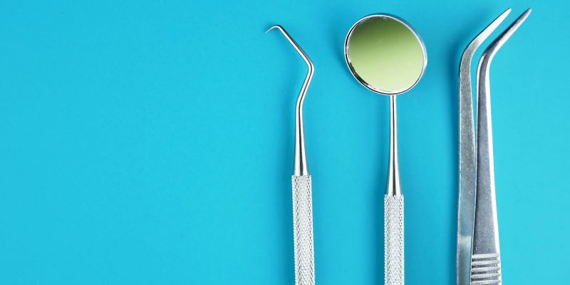 Professional Dentist tools in dental office: dentist mirror, forceps curved, explorer curved, dental explorer angular and explorer curved with chip, right. Dental Hygiene and Health conceptual image